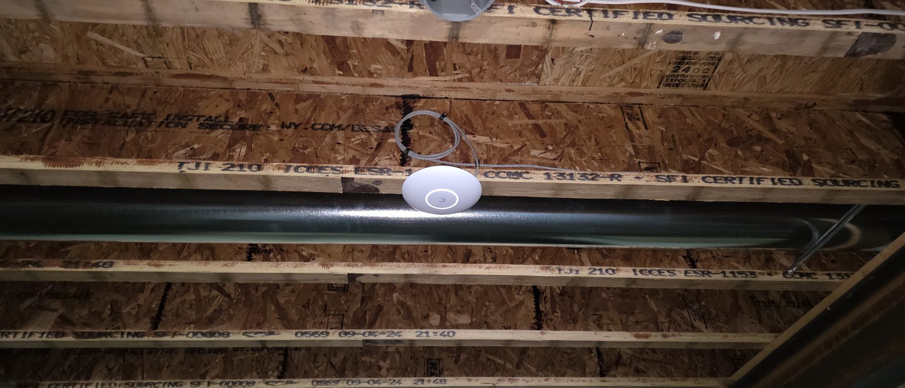 UniFi access point installed by TownLink in an open-ceiling business space